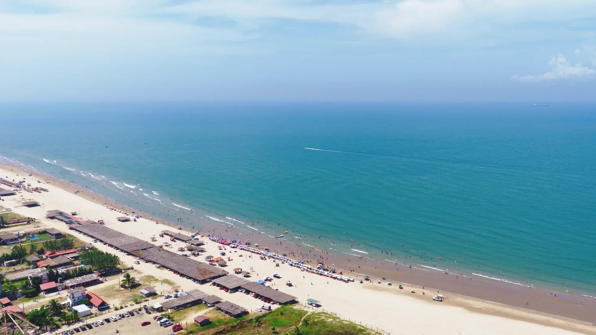 Vista aérea de una playa concurrida con palapas y bañistas cerca de Altamar en Tuxpan, Veracruz